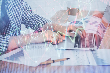 Multi exposure of stock market chart with man working on computer on background. Concept of financial analysis.