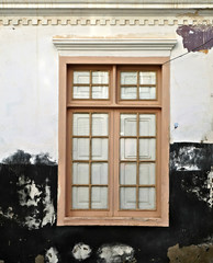 Simple old style wooden frame window, closed. Detail of an old villa house. Home restoration project.