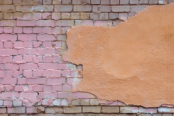 old damaged brick wall with stucco and paint stains