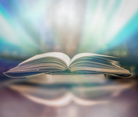 The blurred book that is bewitched with magic, the magic light in the dark, with the bright light shining down as the power to search for knowledge. For research and use as a blurred background