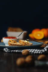 Breakfast, bread and butter with jam and tea on a dark wooden background