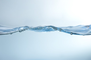 Water splash on blue background. Aqua flowing in waves and creating bubbles. Drops on the water...