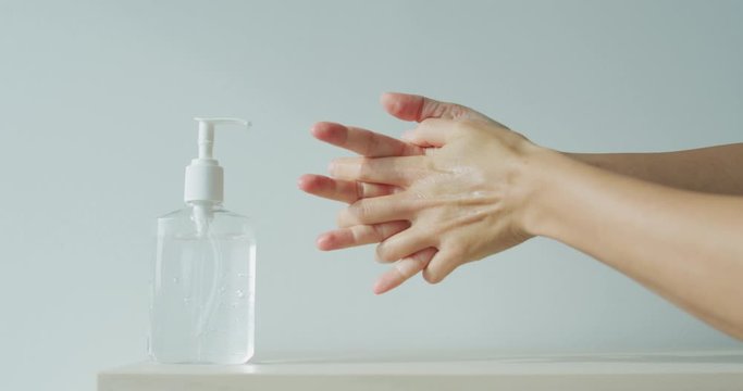 Woman's hands using hand sanitizer gel