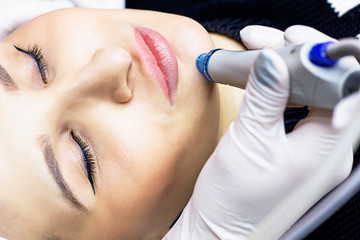 close-up Face cleansing, serum vacuum hydro-peeling. young woman enjoys a radiant face in a beauty salon, cosmetic facial skin care, professional doctor, freshness and modern technology