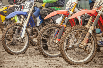 Fototapeta na wymiar Dirty wheel of motorcycle after the race. Detail of the motocross bike. Extreme sport. 