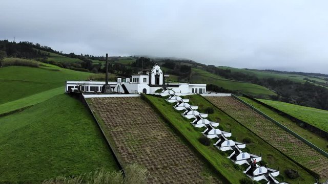 4K aerial footage of an amazing church on the top of the mountain surrounded by green fields on a cloudy day in S&atilde;o Miguel Island, Azores, Portugal.