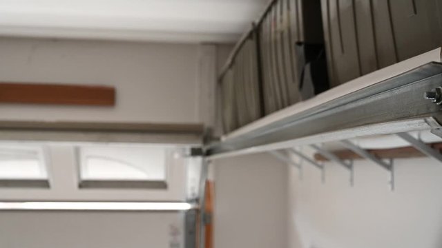 Close focus on track of Residential insulated garage while door is being opened 