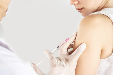 closeup doctor hand holding  syringe vaccination to female patient
