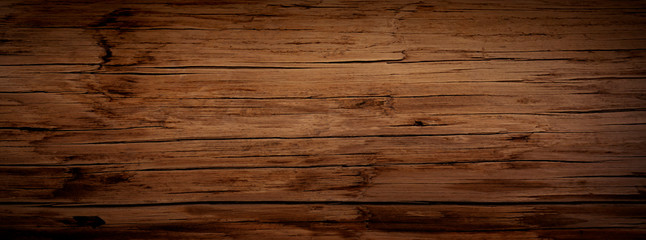 Dark stained reclaimed wood surface with aged boards lined up. Wooden floor planks with grain and...