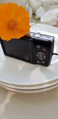 Closeup of compact camera on white plate blurred background.  Technology equipment concept.