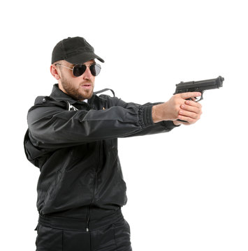Male police officer with gun on white background