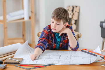 Cute little builder with drawings in room