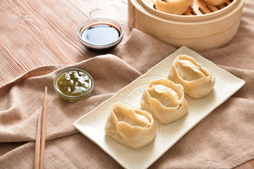 Plate with oriental dumplings on table
