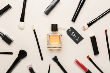 Bottle of perfume with makeup cosmetics on white background