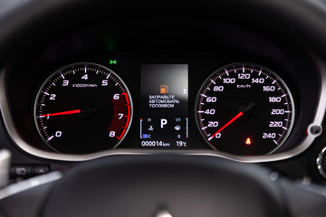 Fototapeta premium dashboard of the car is illuminated by bright illumination. Speedometer, circle tachometer, oil and fuel level.