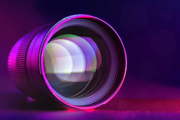 Fototapeta na wymiar The camera lens with purple pink backlight. Optics. Horizontal macro photo