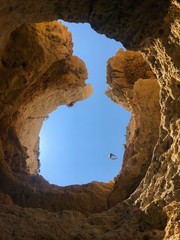 Blue sky through limestone hole in the caves of the Algarve
