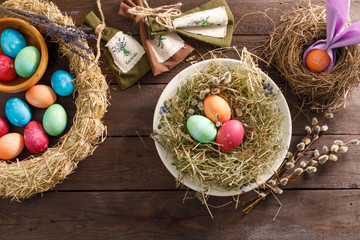 Still life many colorful easter eggs on a wooden background. Rustic. Decoration from natural fabrics and herbs. Easter celebration concept. Flat lay