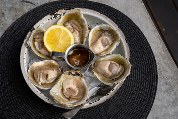 Open oysters with lemon in a white plate