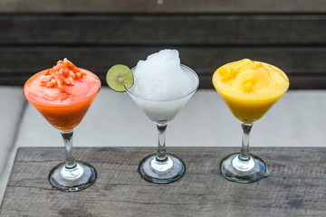 Frost drinks of various flavors are served on a wooden table on the roof top.