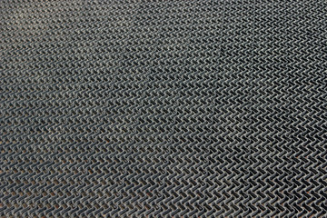 texture of black gray rubber rug mat on the doorstep of a store or restaurant