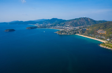 Fototapeta premium Aerial view of the coastline of Phuket island with tropical sandy beaches and mountains at sunny day, Thailand