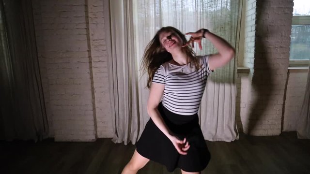 Teenage girl does a dance move in the studio slow motion