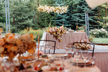 a table of bride and groom in tent in the open air
