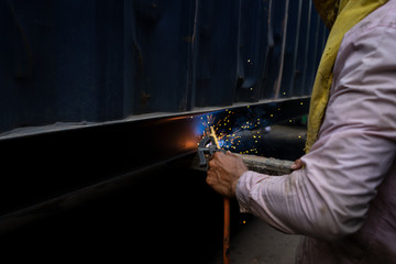 A repairman with welding steel to repairing a container in the container depot service.