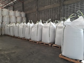White hemp sacks containing chemical fertilizer Large yellow-green sidebar placed on wooden...