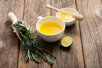 cup of herbal tea and honey, sage, lavender, thyme, iceland lichen herb leaves on scoop