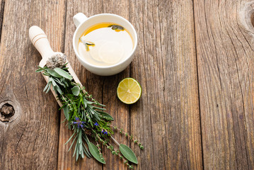 cup of herbal tea and sage, lavender, thyme, iceland lichen herb leaves on scoop