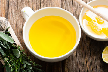 cup of herbal tea and honey, sage, lavender, thyme, iceland lichen herb leaves on scoop