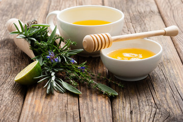 cup of herbal tea and honey, sage, lavender, thyme, iceland lichen herb leaves on scoop