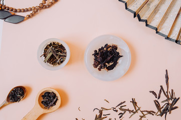Chinese tea party. Dry granules of different types of tea in a white stone Cup, in wooden spoons on...