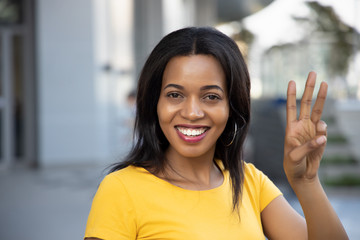 Black African woman pointing, counting three finger; portrait of happy smiling black African woman pointing up 3 fingers for number three or 3 points concept ; black African woman model, casual theme