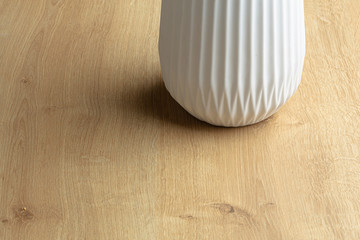 White design pot vase close up still on a wooden surface
