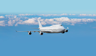 Fototapeta na wymiar White passenger giant airplane in the clouds - Travel by air transport