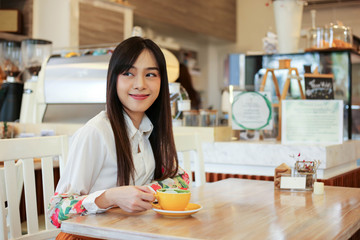 Beautiful asian woman eating delicious  waffles in coffee shop cafe.