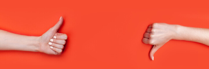 Female hand shows thumb up and thumb down on red background, banner format, copy space