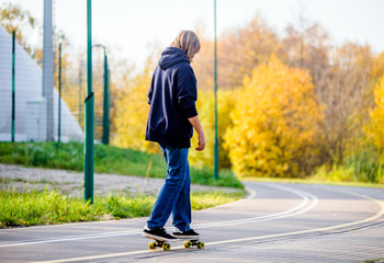 Guy rides a skateboard in the autumn Park