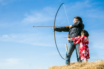 asian mother and daugther playing arrow on straw
