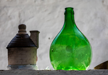 Alberobello, Italy - Septembet 16, 2019: Demijohn wine bottle at cafe in Trulli village in Alberobello, Italy.