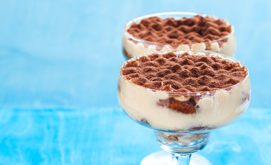 luxury tiramisu dessert in a cocktail glass decorated with cocoa