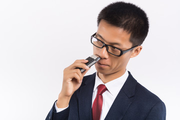 A business man is shaving his beard with an electric razor