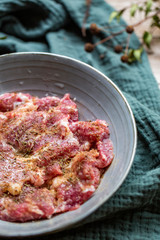 Fresh-marinated raw steak with Vanilla and pepper in bowl on wooden background.