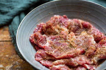 Fresh-marinated raw steak with Vanilla and pepper in bowl on wooden background.