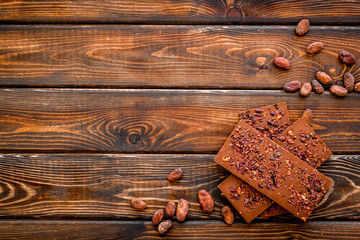 Chocolate - stack of dark bars - on dark wooden background top-down copy space