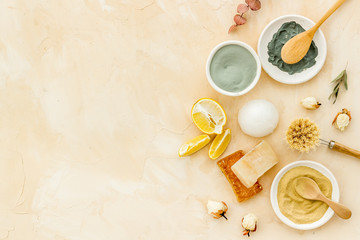 Clay mask, natural facial cosmetic set with herbals on brown background - top view