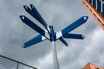 A blue signpost between buildings